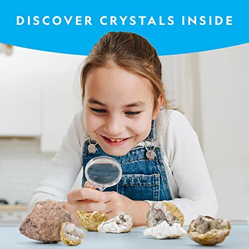 Child examining geodes with a magnifying glass.